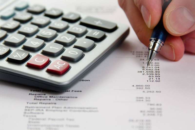 A person reviewing financial documents while comparing loan offers