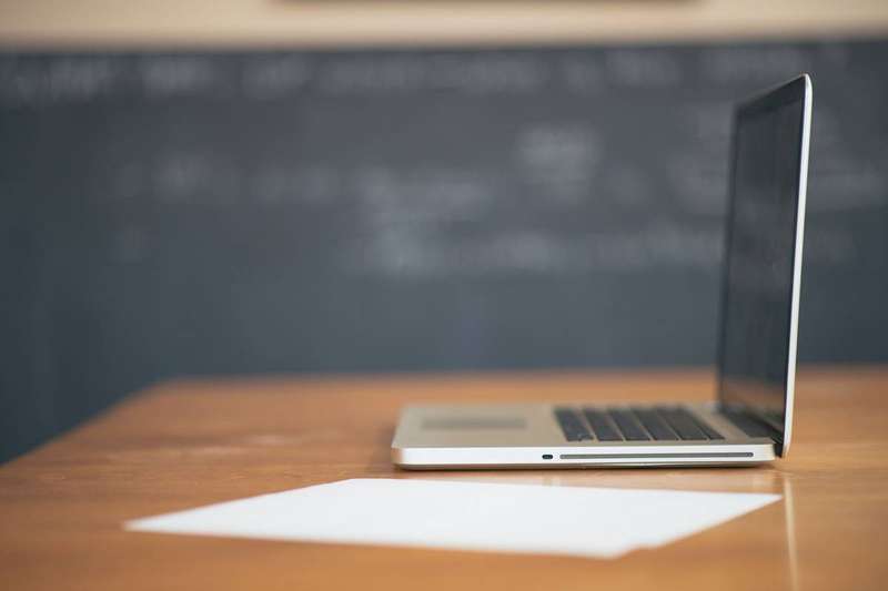 A person working at a desk with a laptop, researching salary data