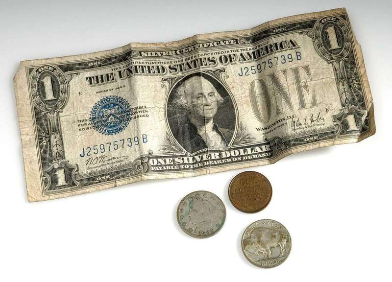 A dollar bill and coins, a reminder that interest is real money on top of what was borrowed