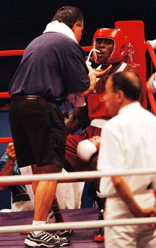 A boxer drinking water between rounds, rehydrating during exertion