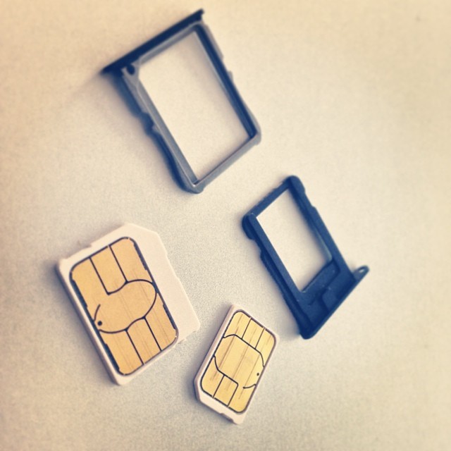 Mini, micro, and nano SIM cards next to their trays, the plastic dual eSIM replaces
