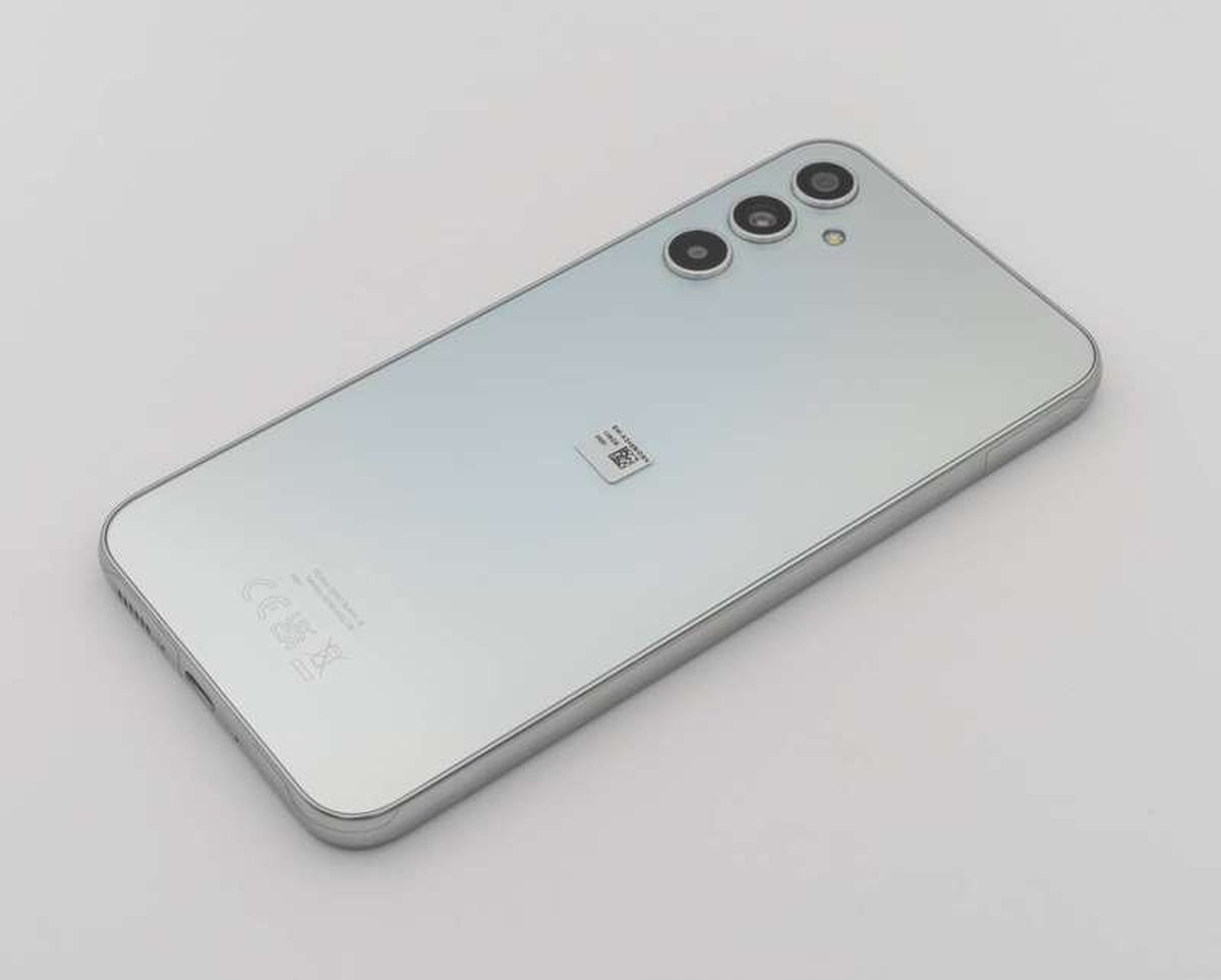 A modern smartphone on a desk, the kind of device that stores its SIM as a downloadable eSIM profile