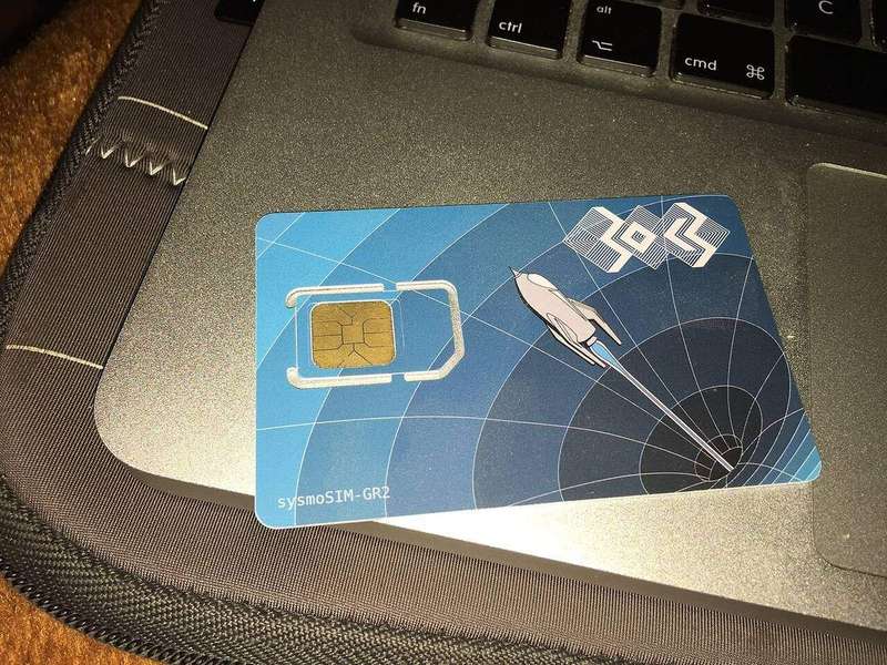 A physical SIM card next to its packaging, the removable kind a factory reset cannot touch