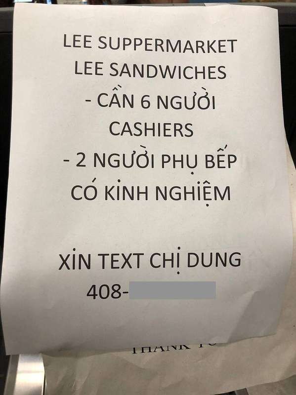 A help wanted sign in a supermarket window