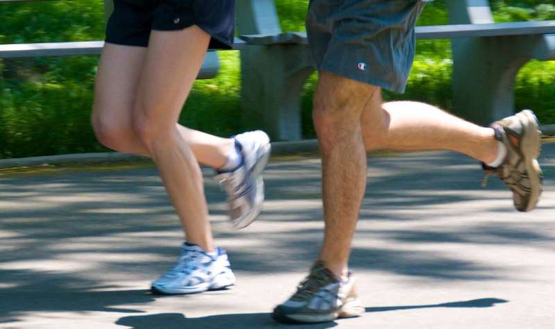 Two joggers mid-stride; the legs and calves are the muscles where drug-related cramps most often strike