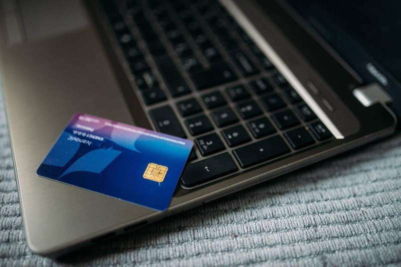 A bank card resting on a laptop keyboard, the way most people review their statements