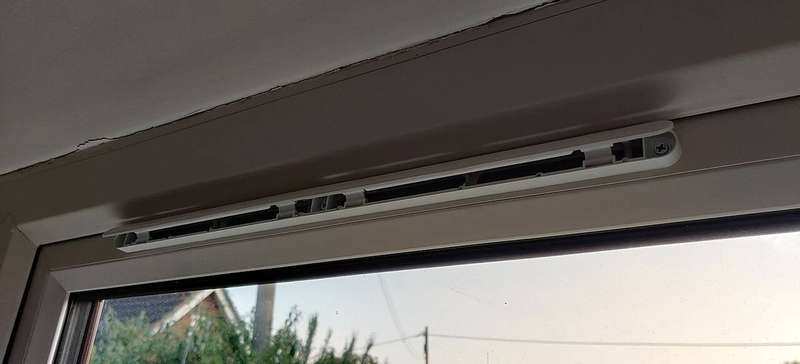 An open trickle vent in a window frame letting air escape