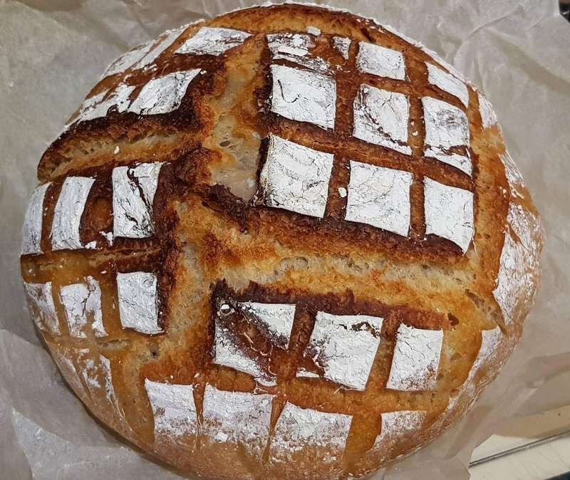 A homemade sourdough cob with a scored crust