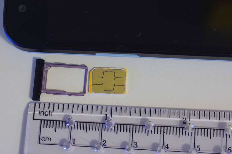 A nano SIM card next to its tray
