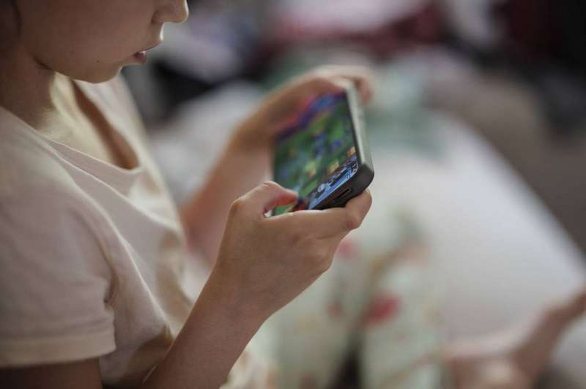 A young child playing a game on a smartphone at home