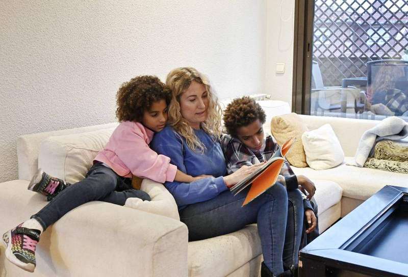 A mother reading a book to her two children
