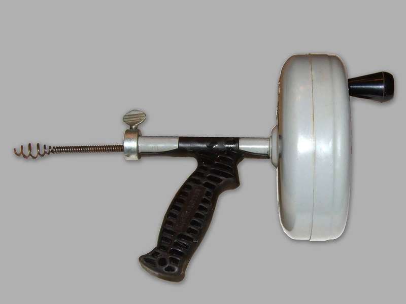 A handheld drain auger, the coiled-wire tool for reaching deep clogs