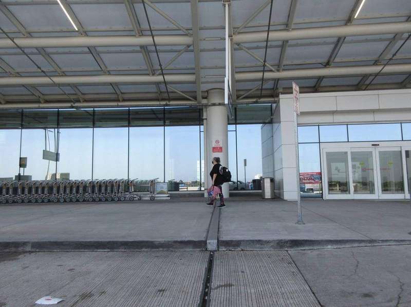 An airport departure terminal with travelers and luggage