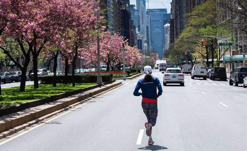 A jogger running down an empty city avenue
