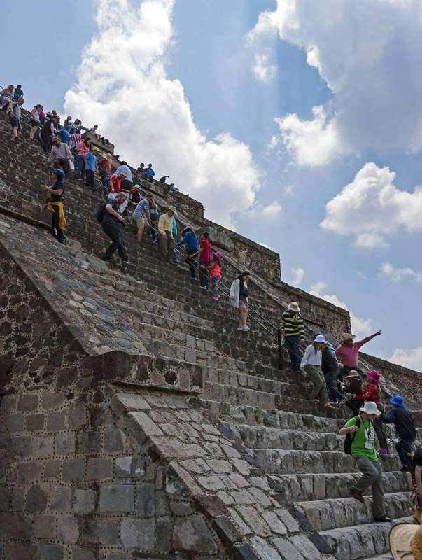 Tourists descending the steep stairs of the Pyramid of the Moon