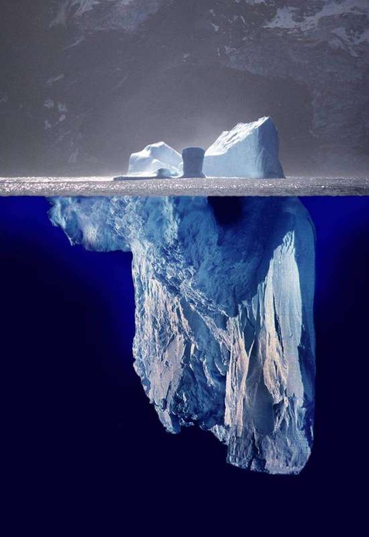 A photomontage showing an iceberg above and below the waterline
