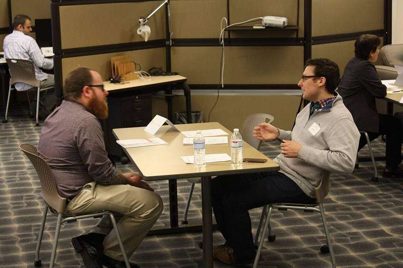 Two people talking across a table in a one-to-one interview