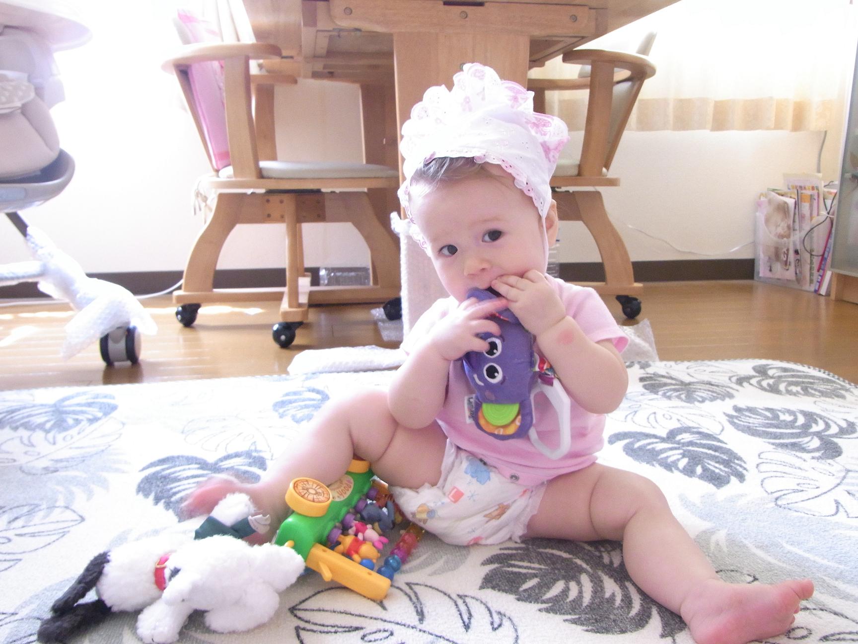 An infant with visible baby teeth smiling