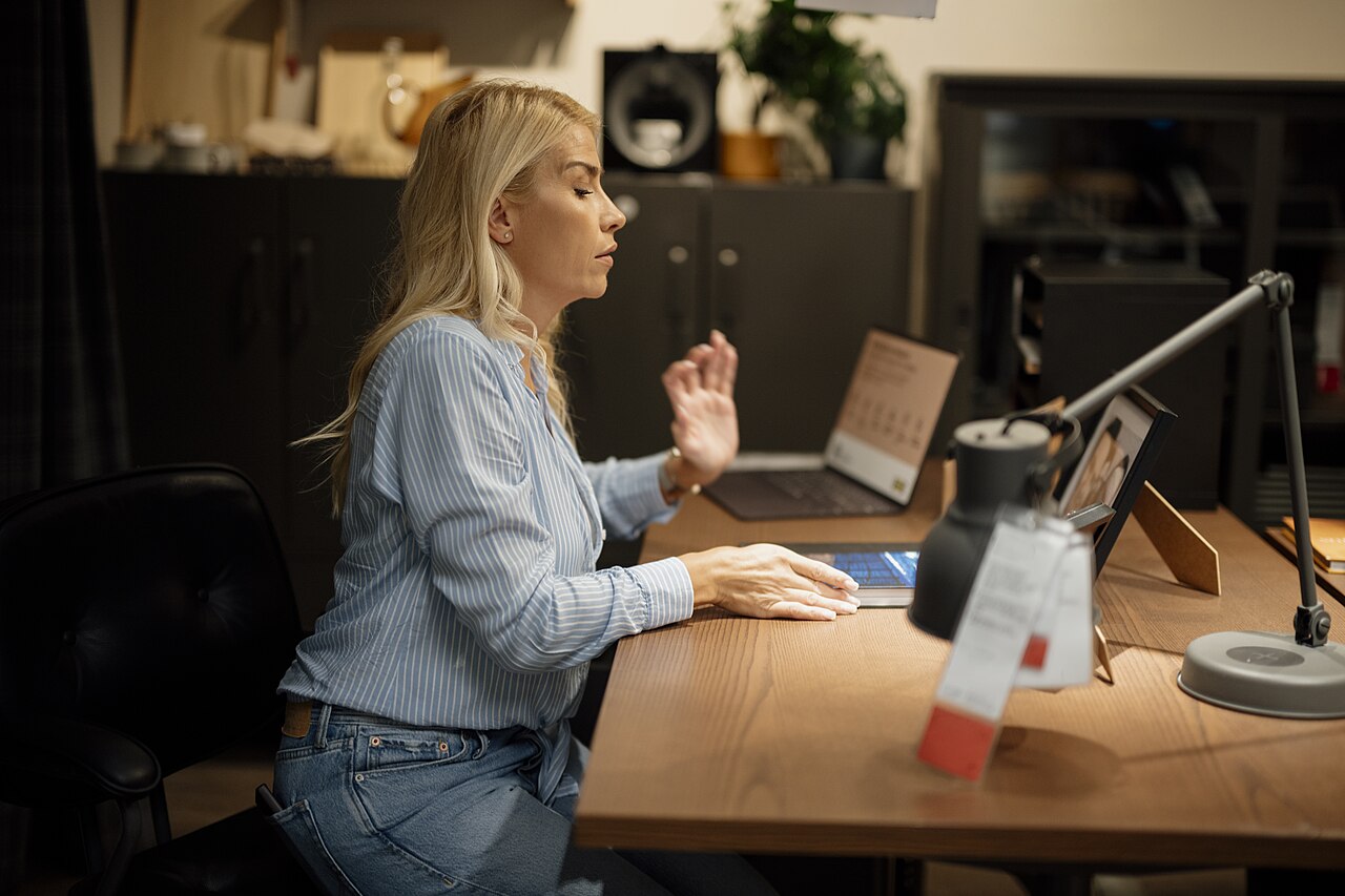 A freelancer working on a laptop at a home office desk