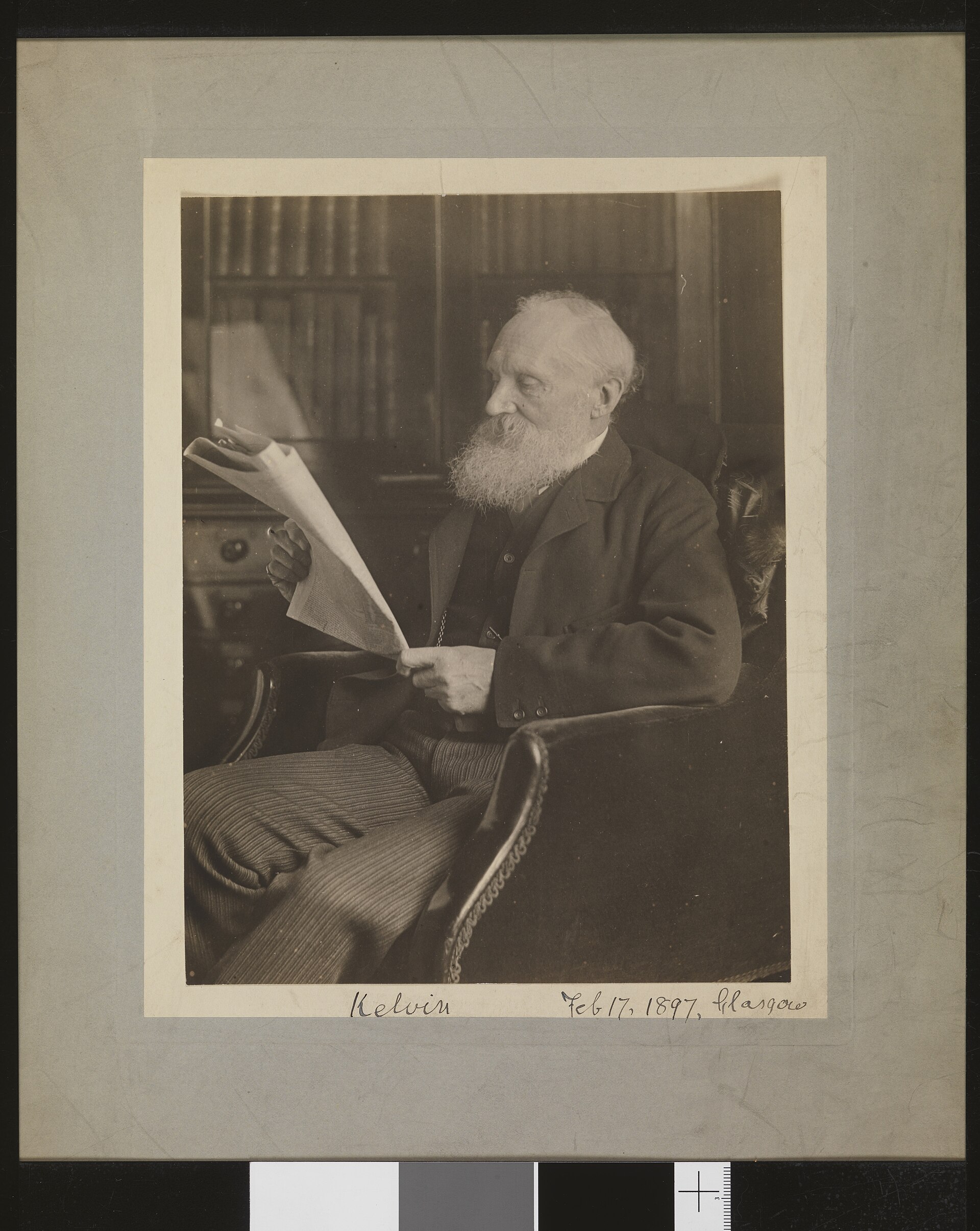 A man reading a newspaper in a study