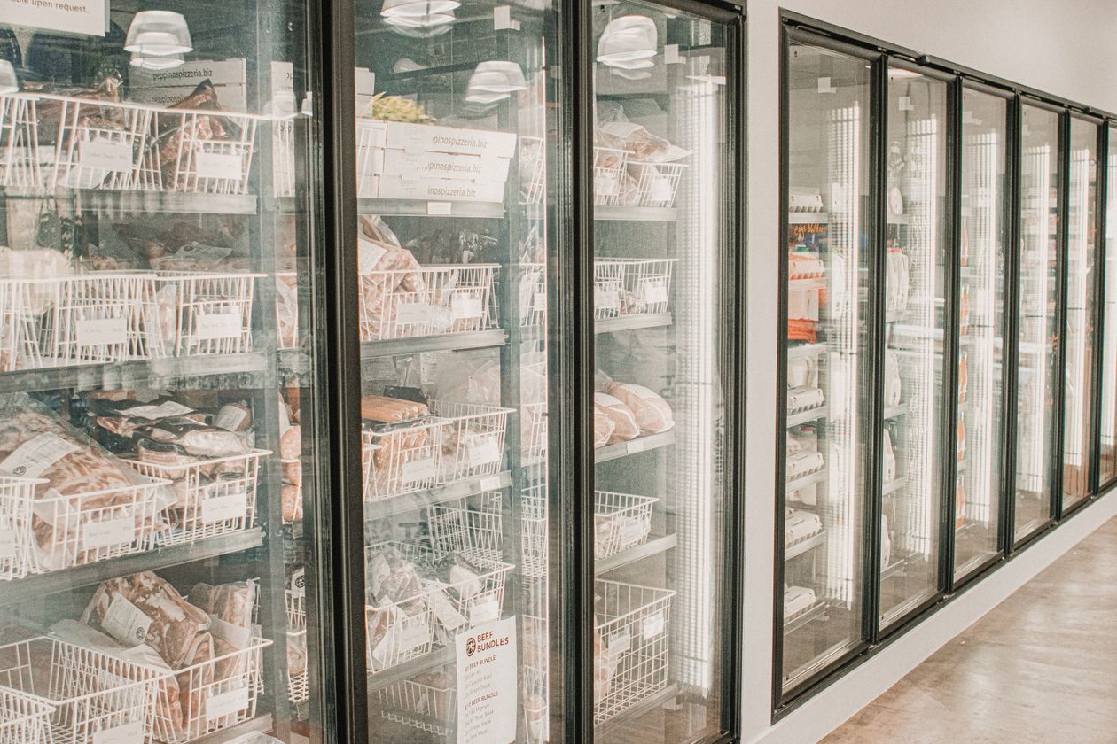 Packaged meats inside glass-door retail freezer cases