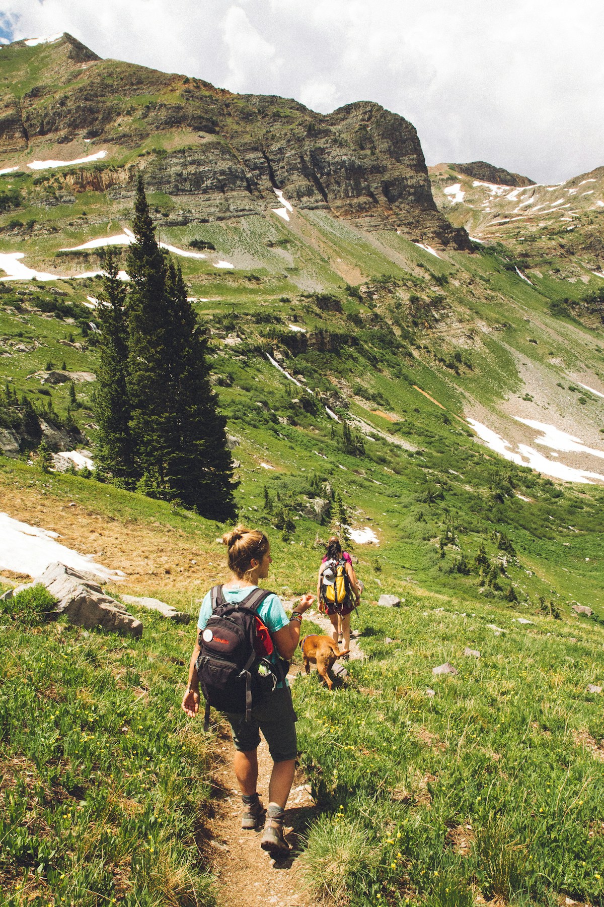 A hiker on a trail with a loaded pack