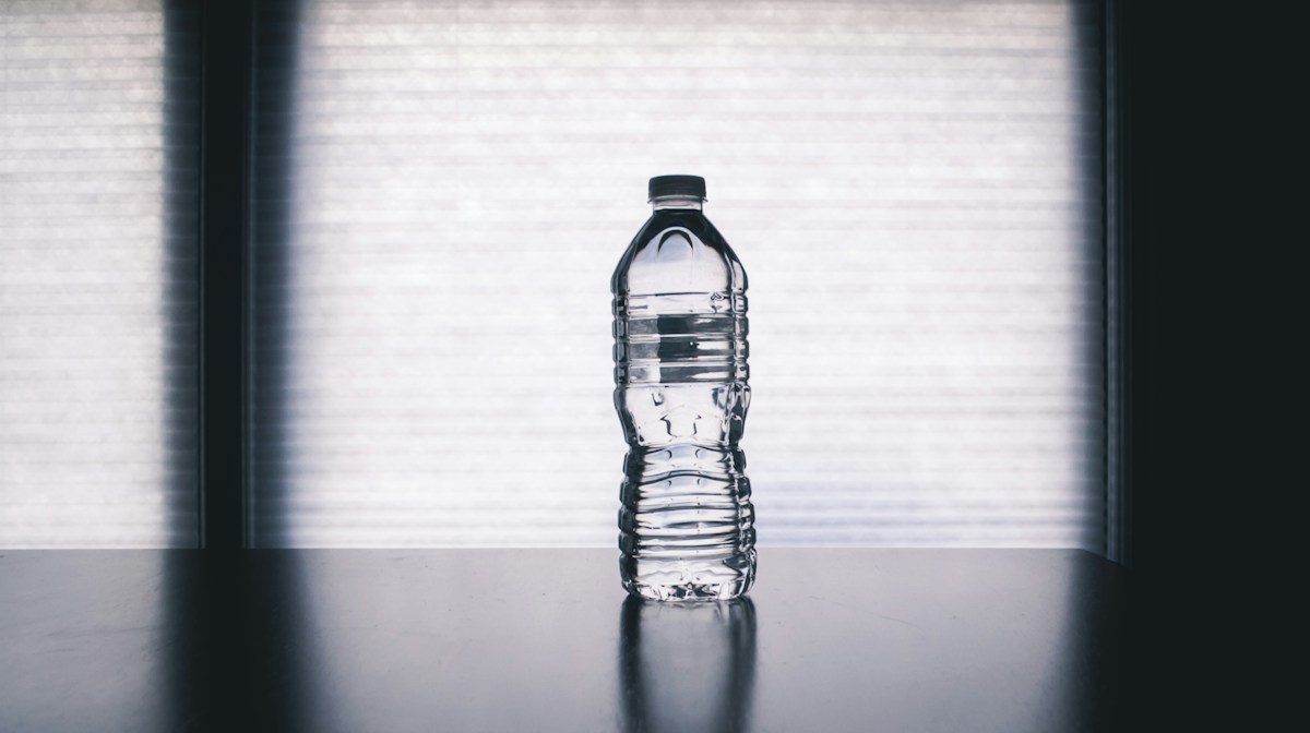 A water bottle and hiking gear arranged before a hike