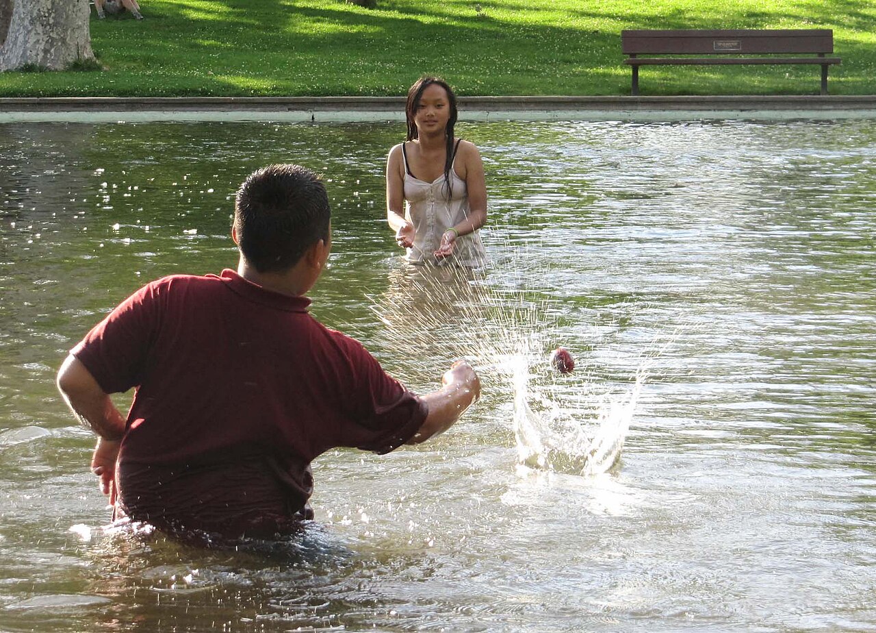 Two siblings playing together with a water toy, showing the cooperative side of the relationship
