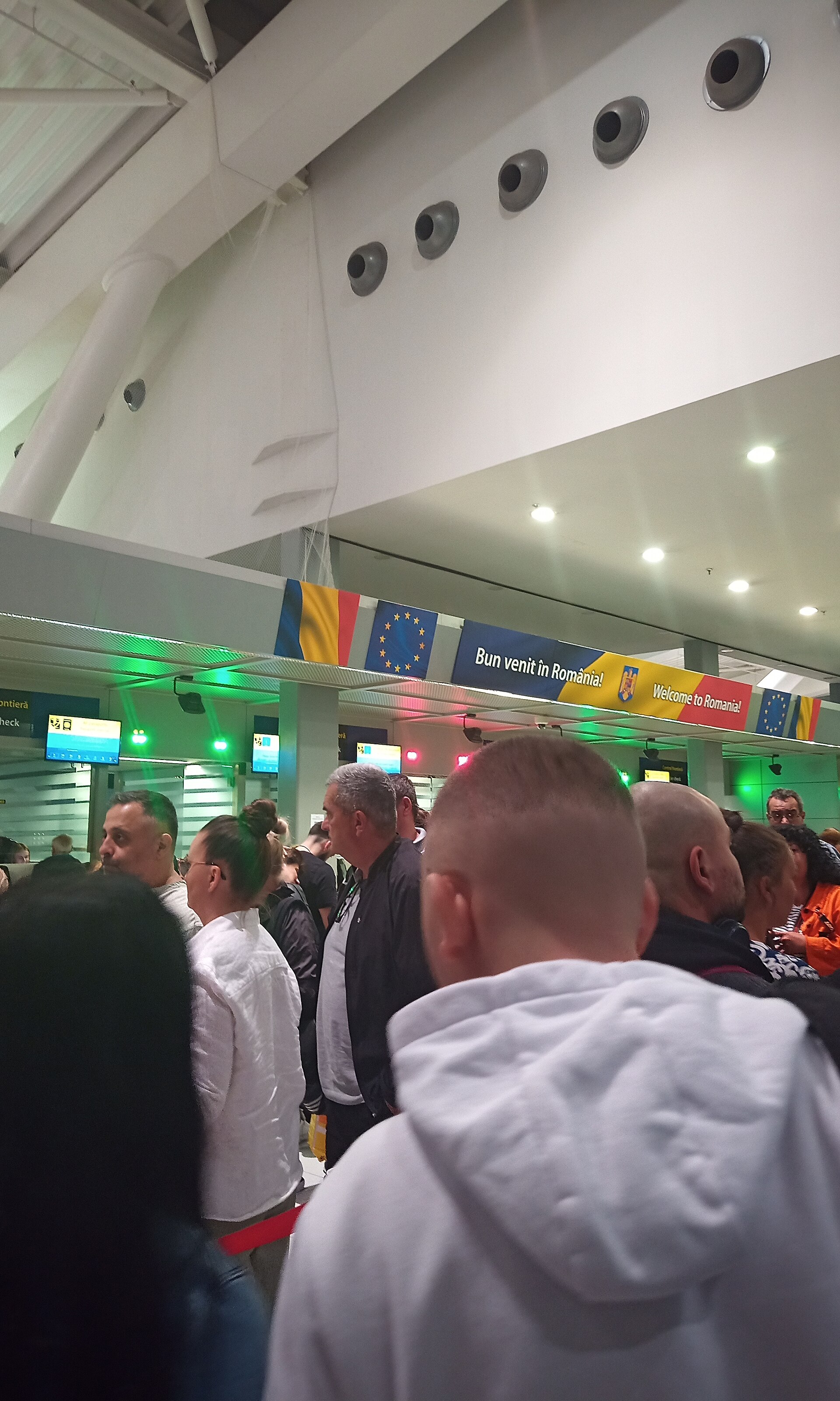 Travelers queueing at passport control booths in Bucharest Airport