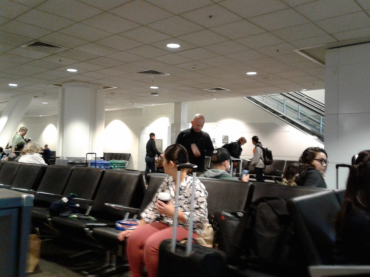 Passengers waiting in an airplane boarding lobby at the gate