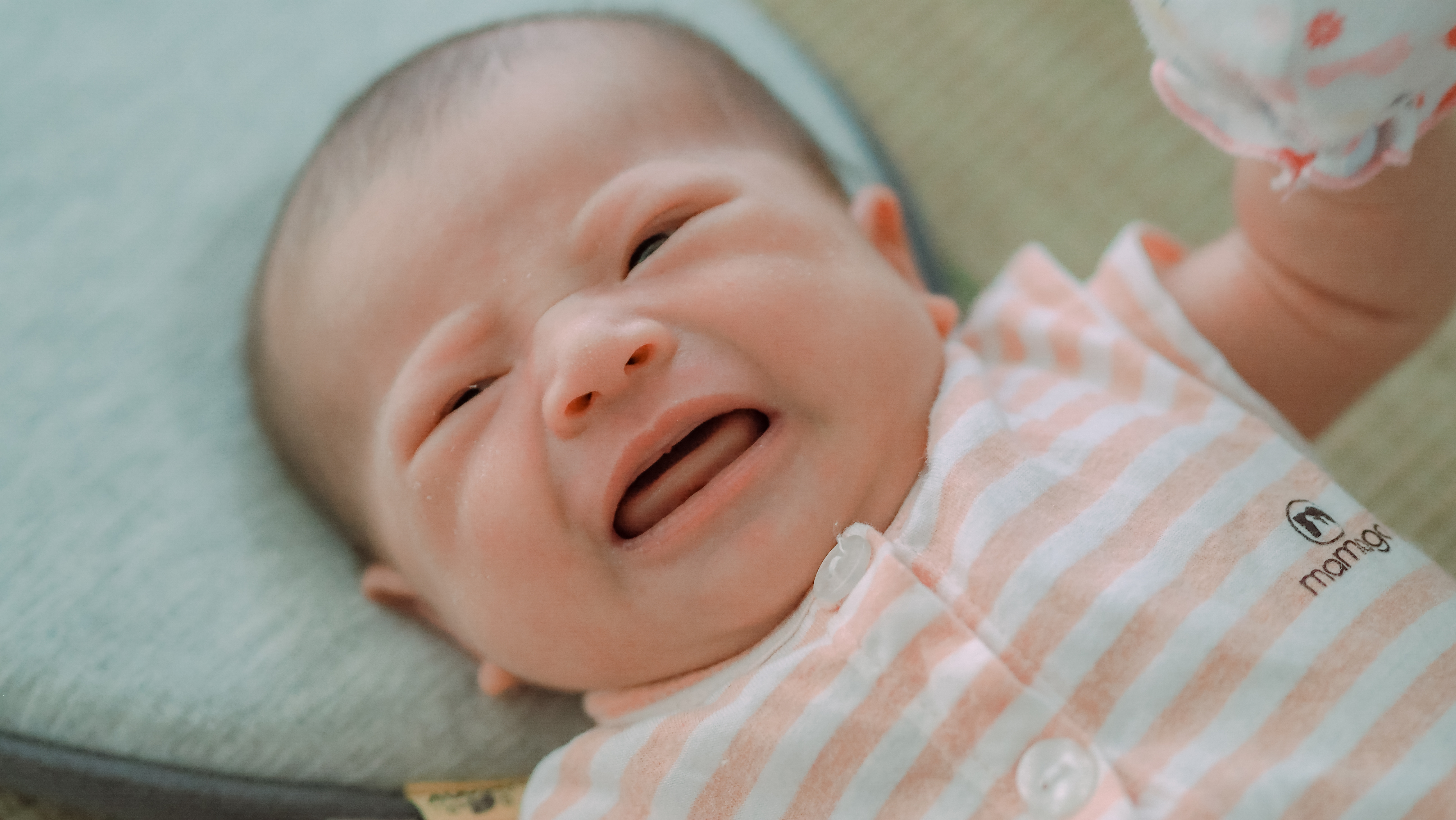 A crying infant being held