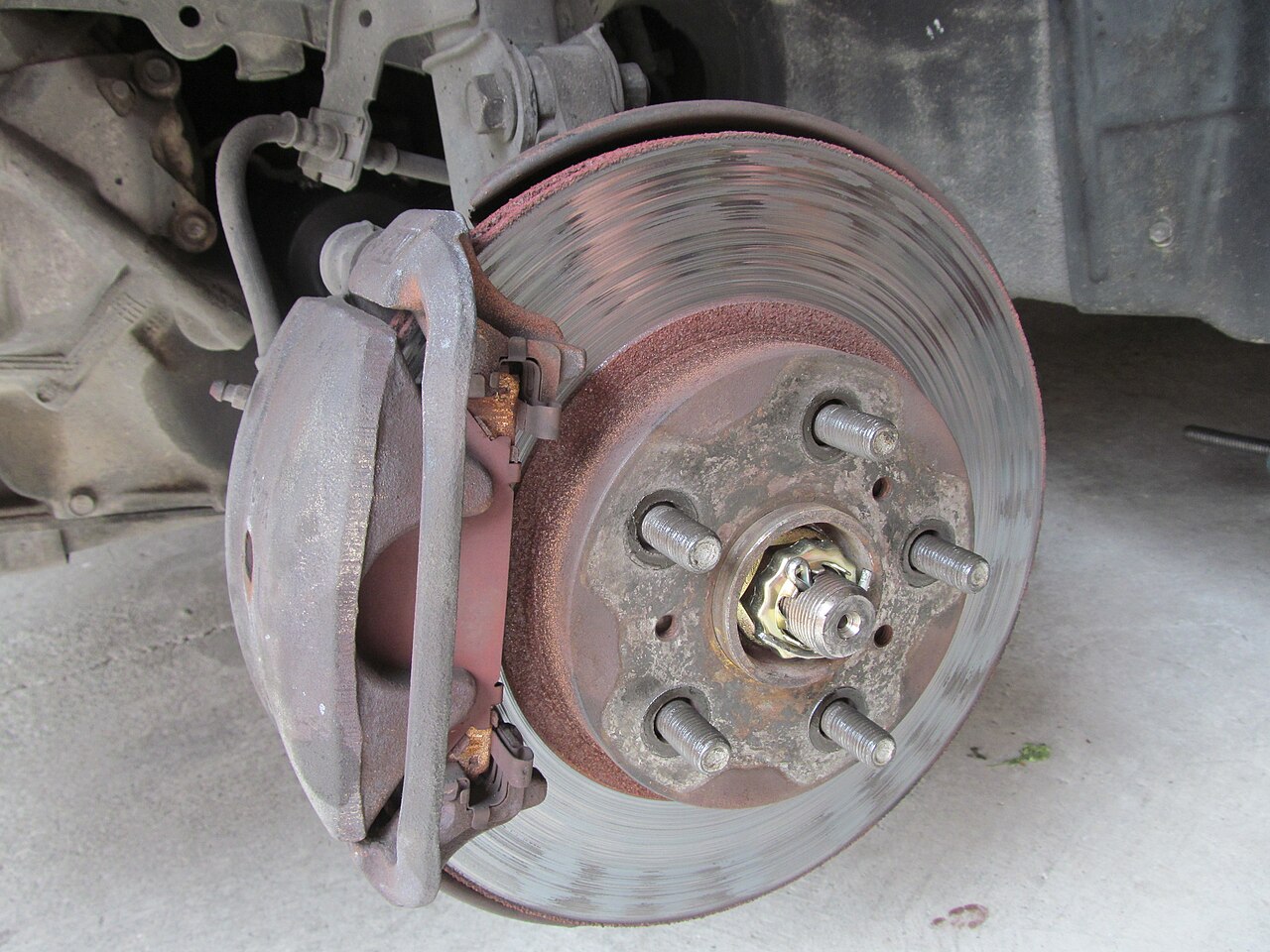 A worn car brake assembly before overhaul