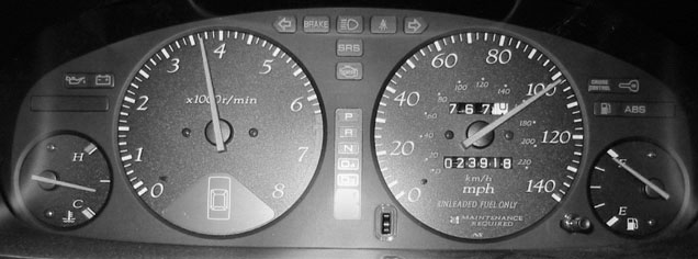 A car dashboard with warning indicators visible to the driver