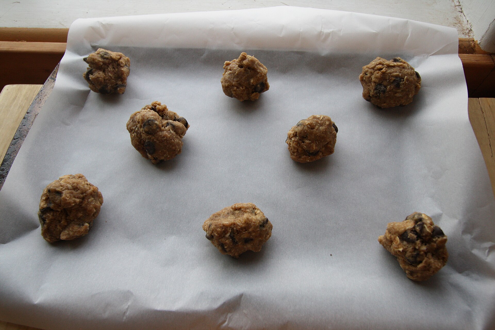 Hands shaping chocolate chip cookie dough