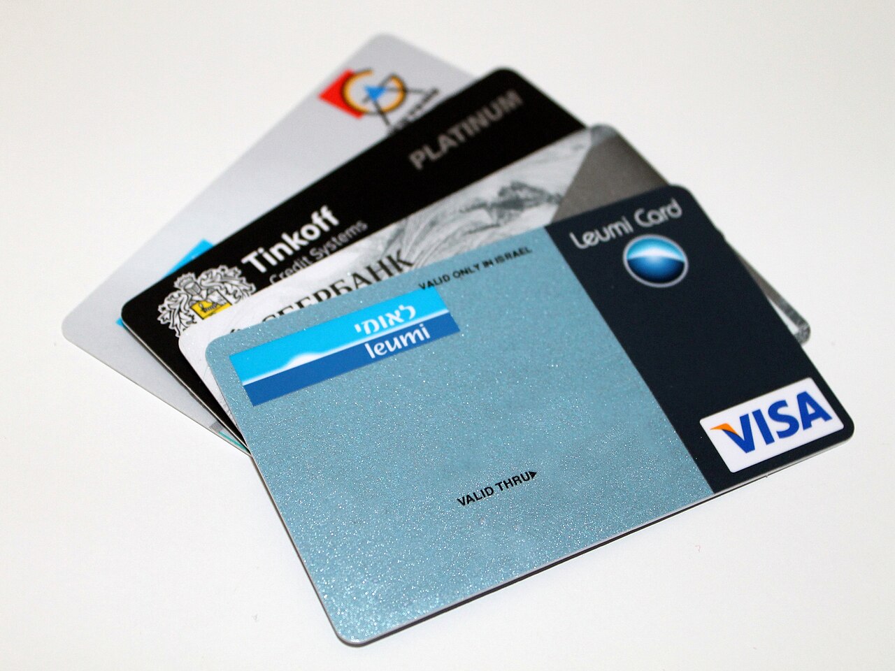 A fan of bank cards on a desk, representing the accounts whose applications trigger hard inquiries