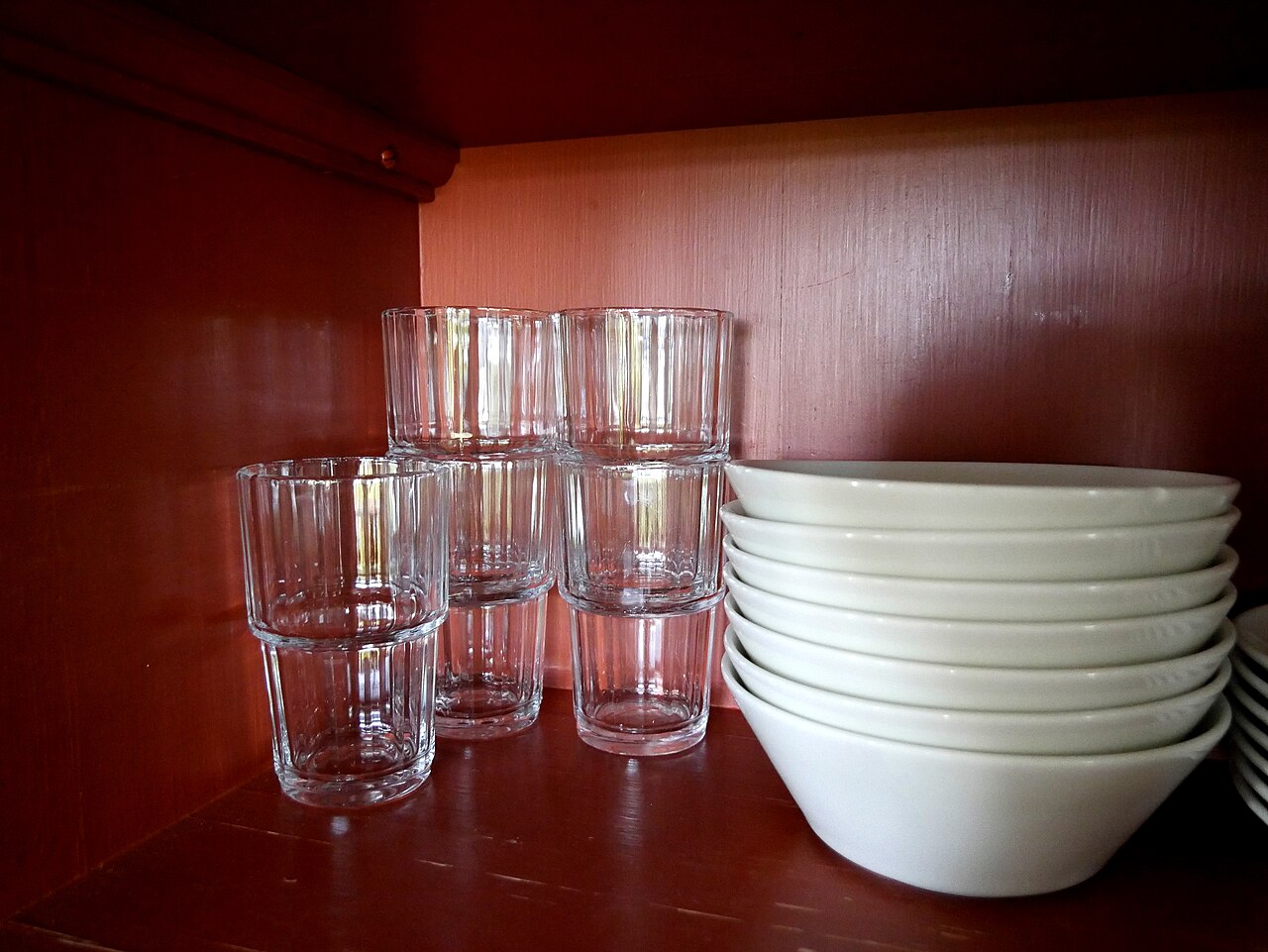 Clean drinking glasses stored in a kitchen cupboard