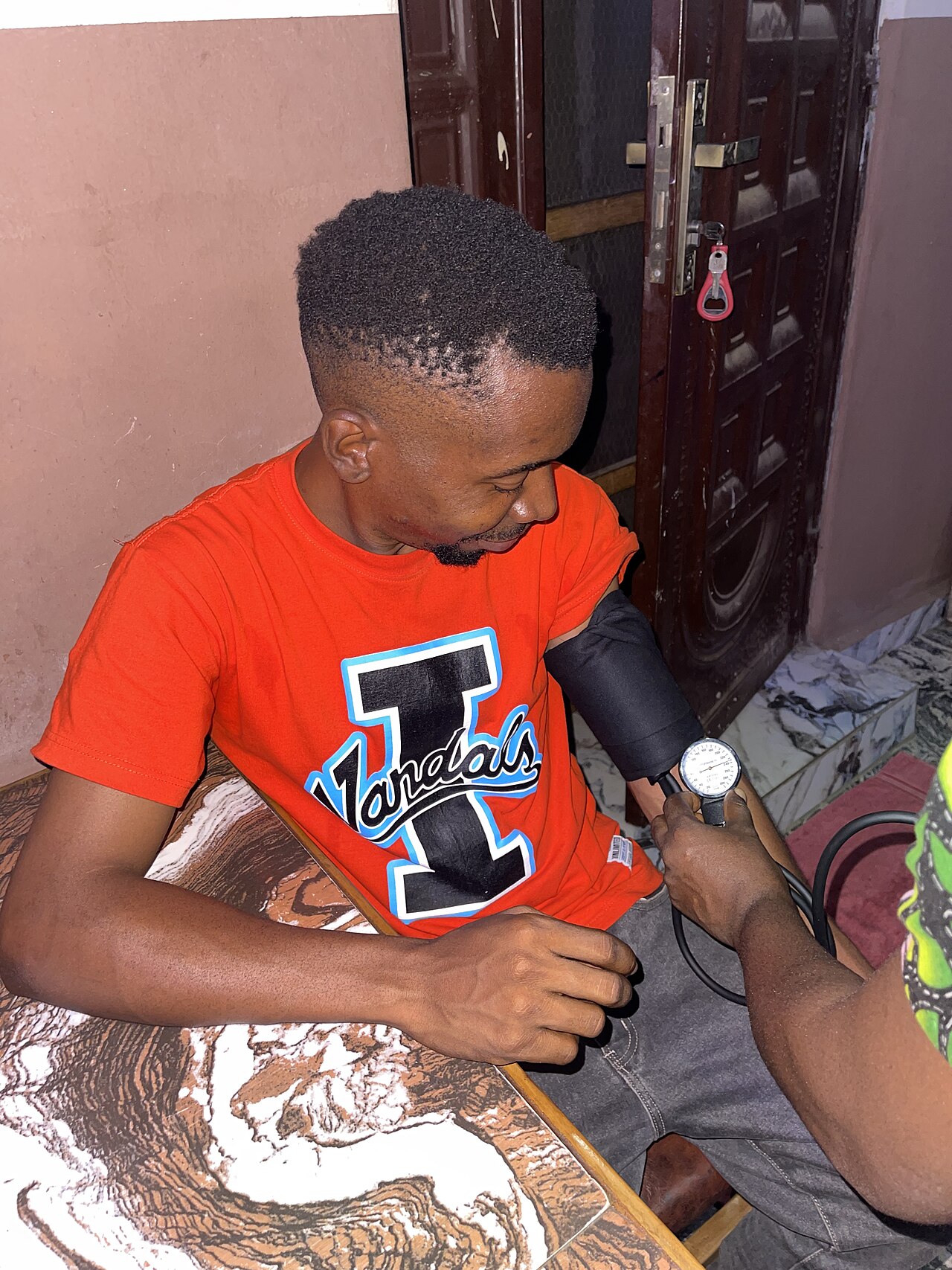 A clinician measuring blood pressure with an aneroid sphygmomanometer and cuff