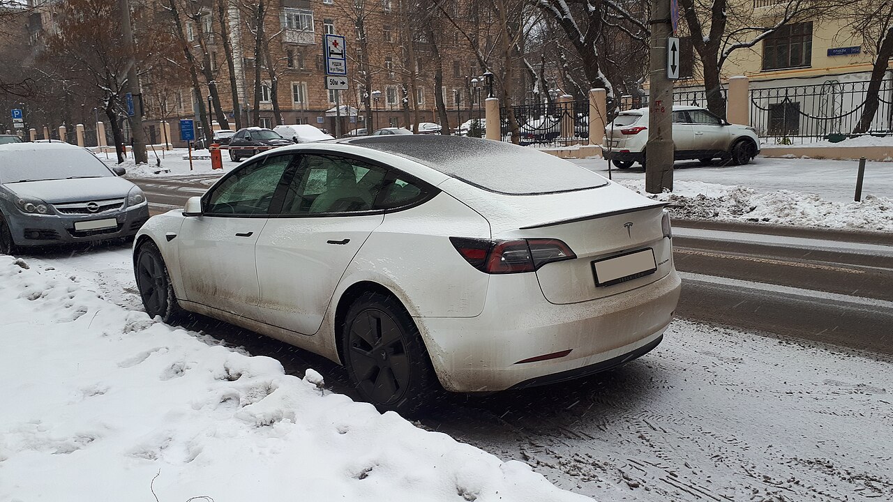 A Tesla Model S from behind, dusted with snow after winter driving
