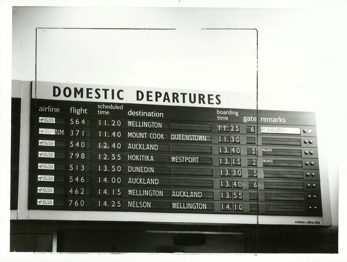 A departure board in an airport terminal showing flight statuses
