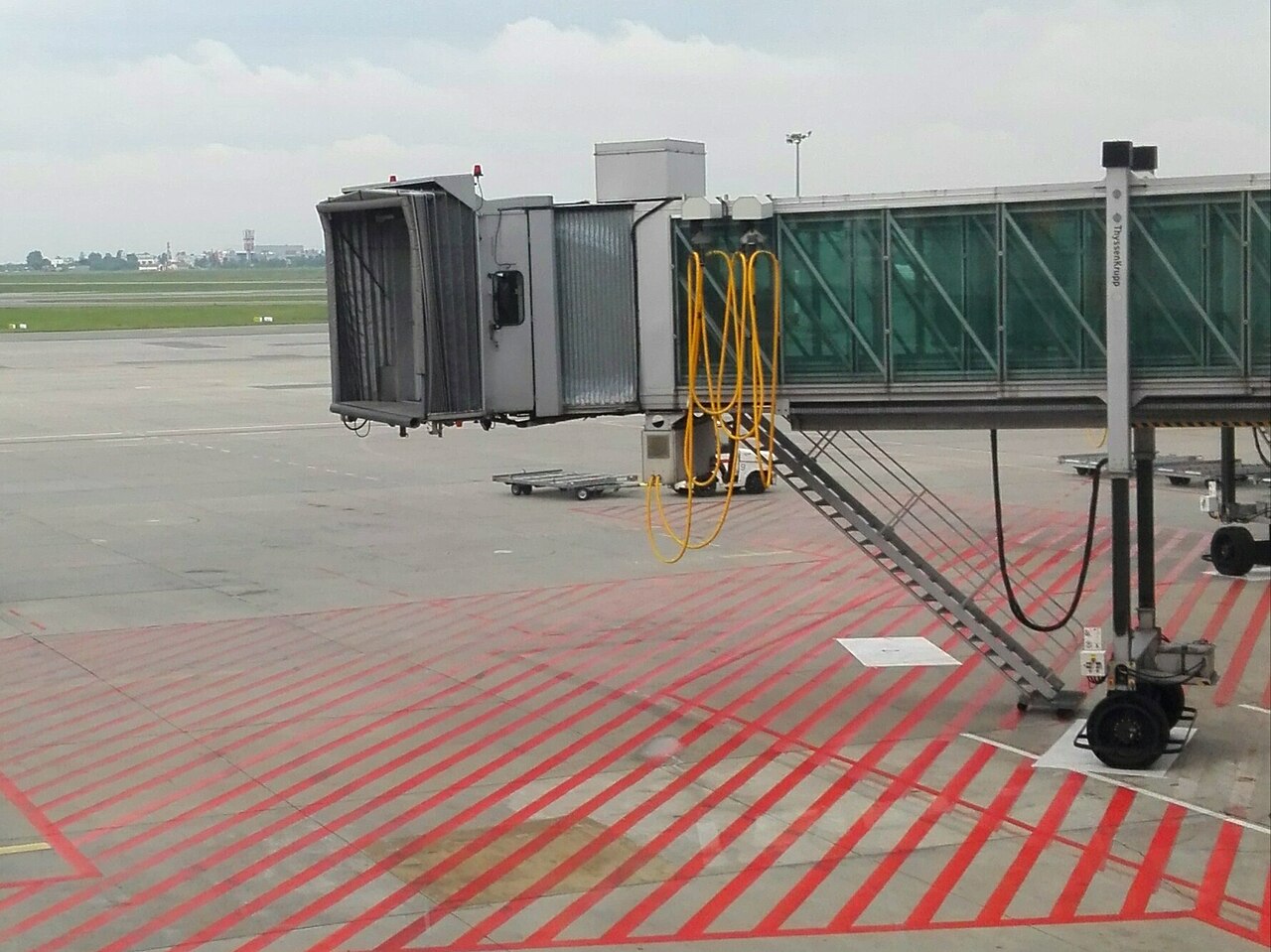 An aircraft connected to a jet bridge at an airport gate