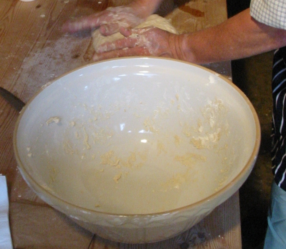 A ball of bread dough resting on a counter before kneading