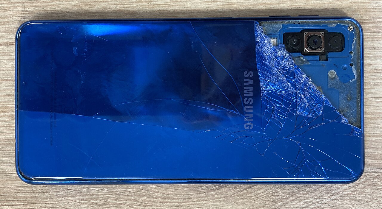 A broken Samsung smartphone with a shattered screen, illustrating the lost or damaged phone scenario