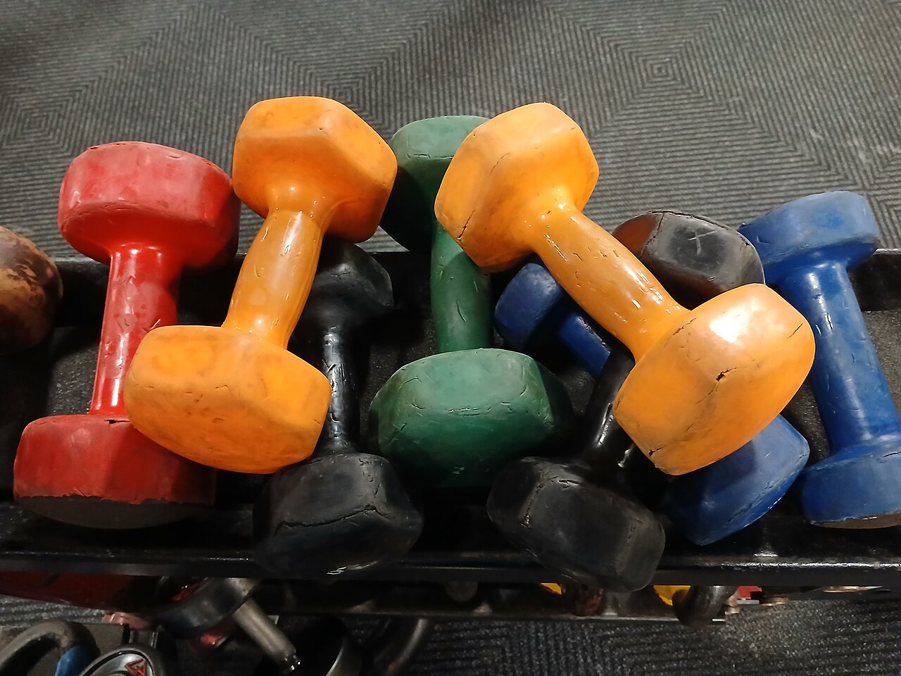 A colorful rack of dumbbells at a gym