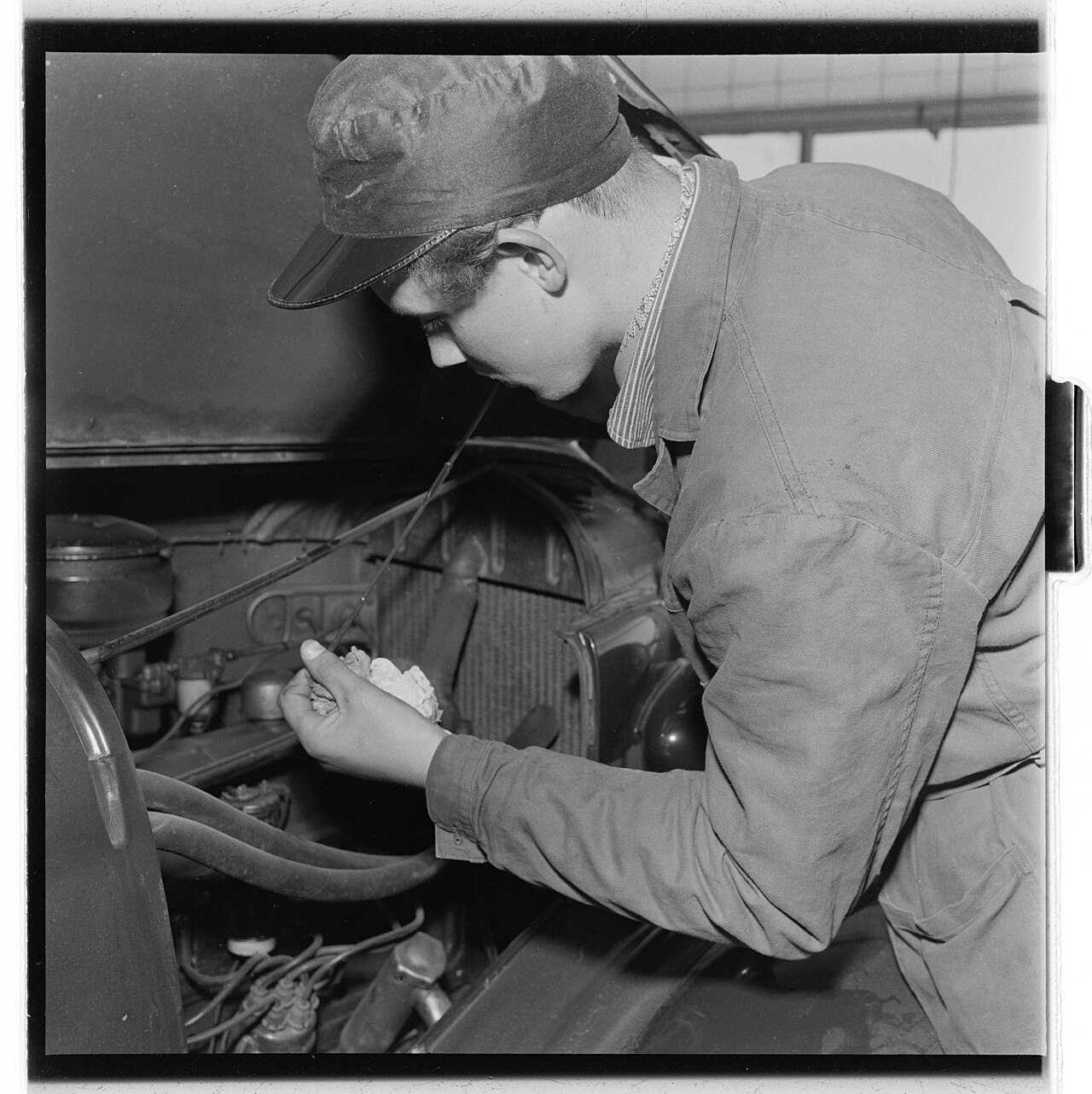 A mechanic servicing a car engine, where oil consumption is diagnosed