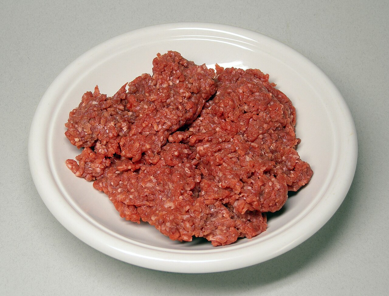 Raw ground beef in a tray showing color variation