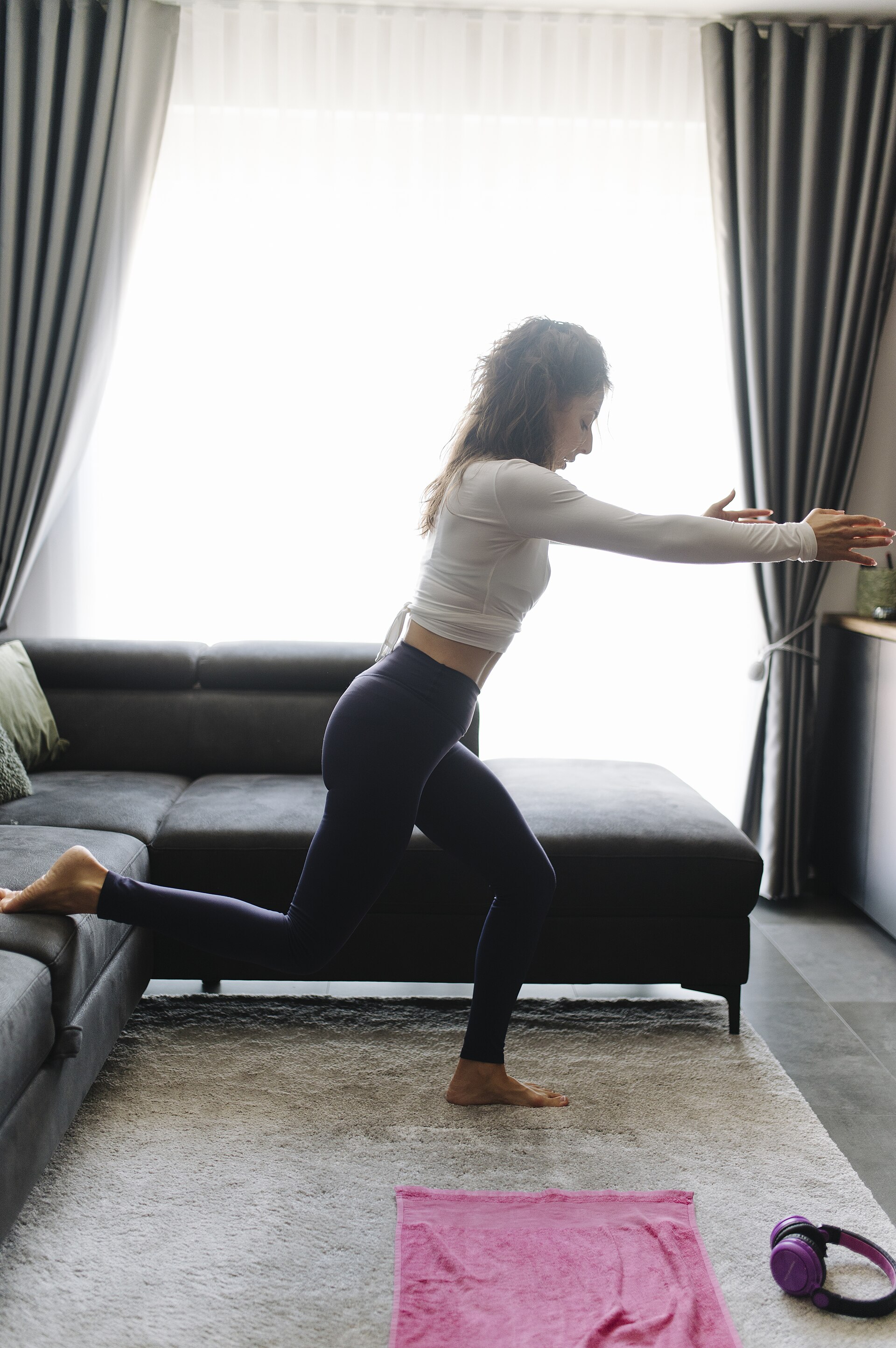 A woman doing light exercise with a mat and weights at home