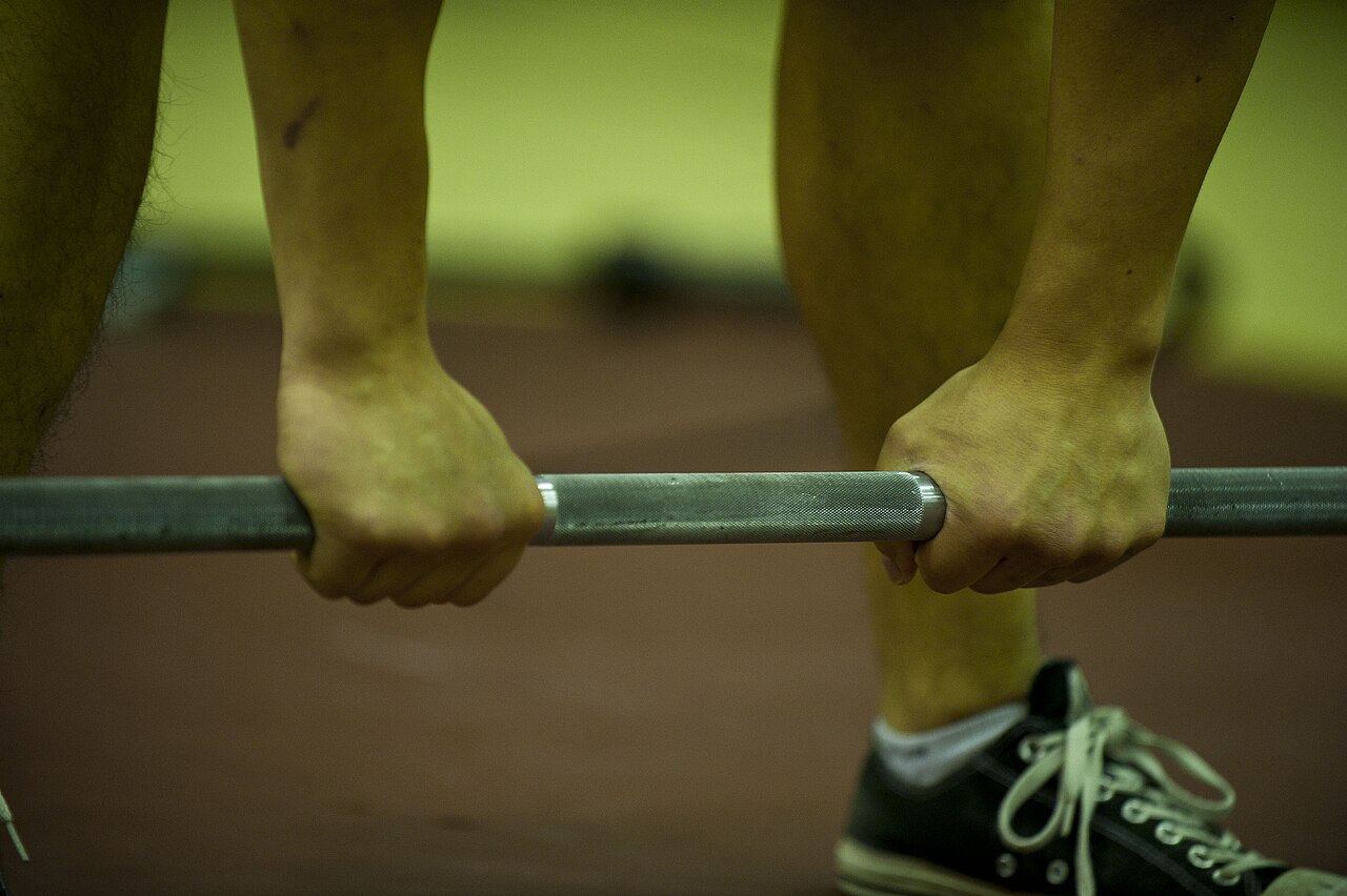 An athlete gripping a barbell before a deadlift