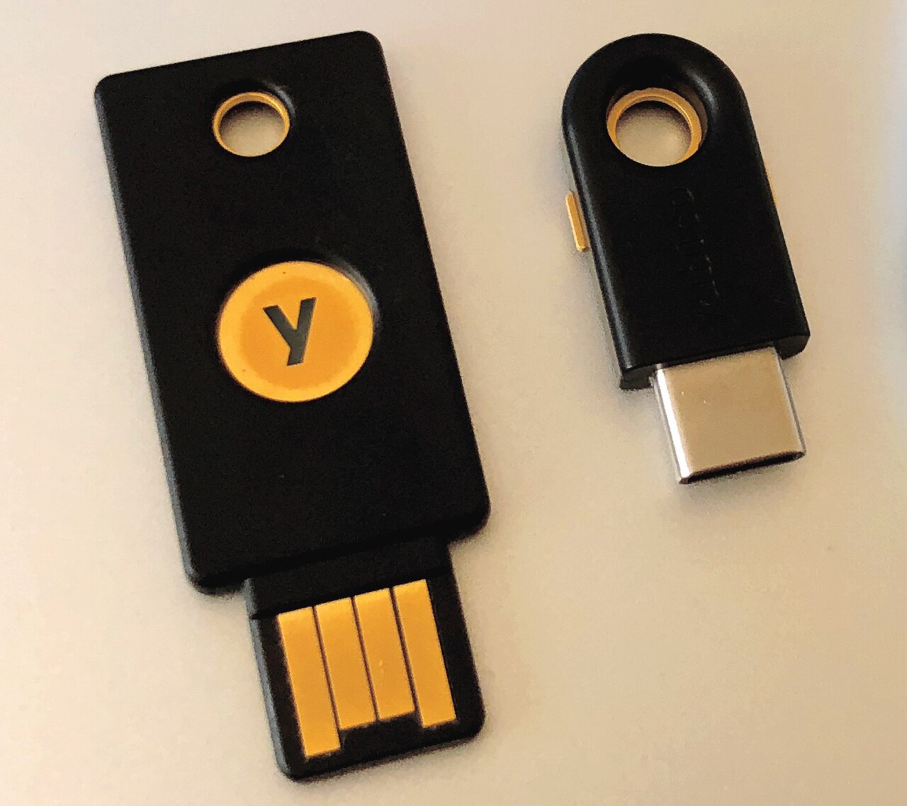 Two YubiKey hardware security keys, the device-bound side of passkey authentication