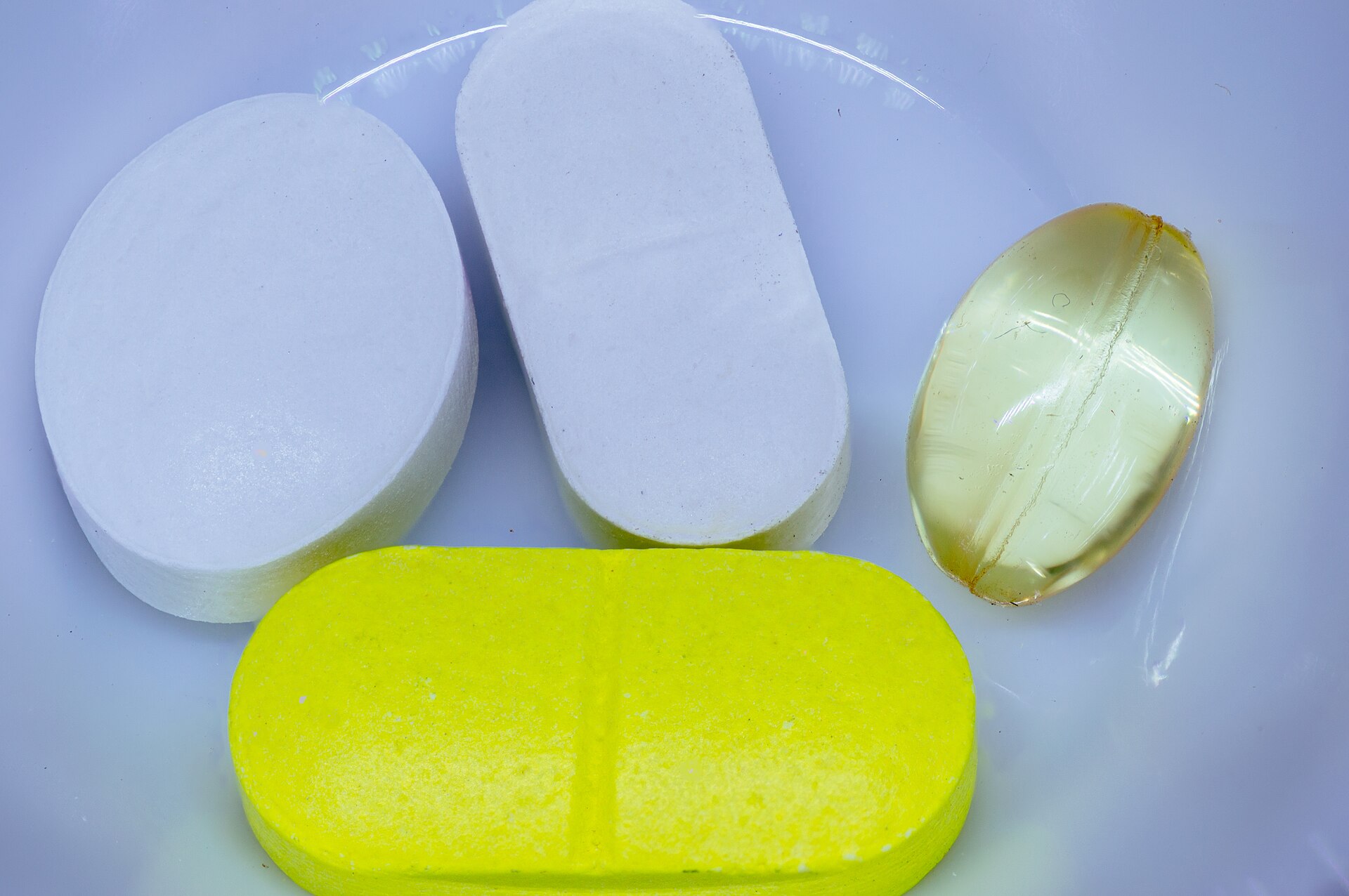 Assorted pills and capsules on a white background