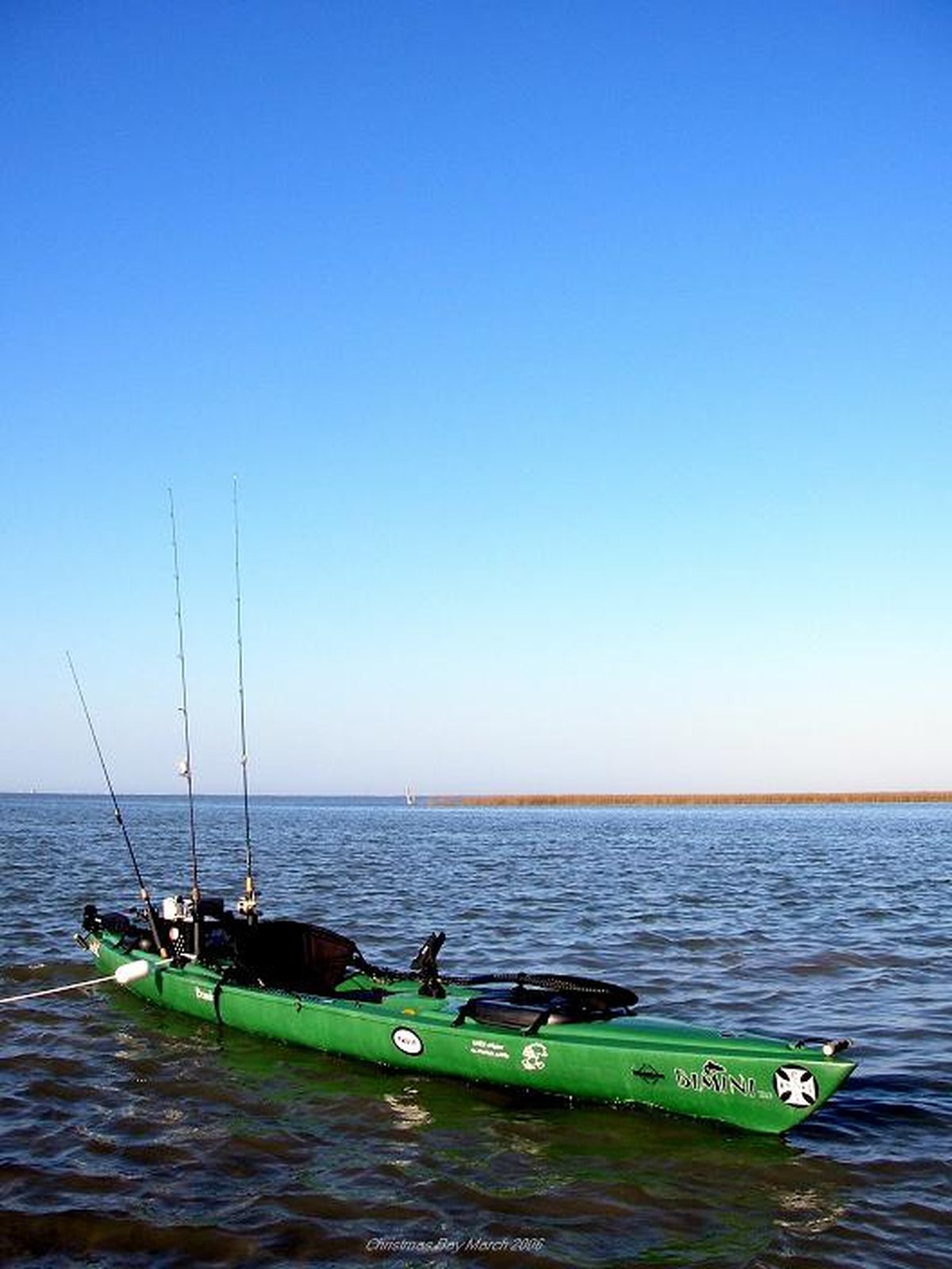 A sit-on-top kayak rigged for fishing, showing its open deck design